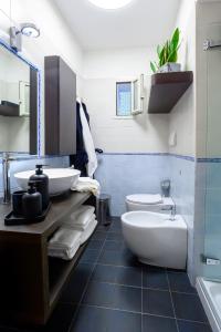 a bathroom with two sinks and a toilet and a tub at Nipare Suite - Dimore Partenopee in Naples