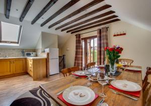 a kitchen and dining room with a wooden table with wine glasses at Dan y Comin in Sennybridge