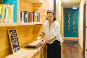 a woman standing next to a counter in a library at Hotel San Miguel in Gij&oacute;n