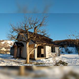 a small house with a tree in the snow at House For Rest VIN in Kolašin +28 photos