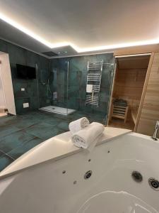 a bathroom with a bath tub with a television and a shower at Real Giardinetto a Toledo in Naples