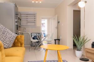 - un salon avec un canapé jaune et une table dans l'établissement Ground Floor Apartment Midrand, à Midrand