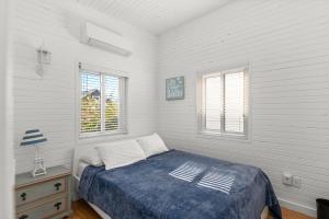 een slaapkamer met een bed en 2 ramen bij 10 Cayuga in Ocean Bay Park