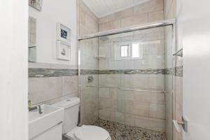 een witte badkamer met een toilet en een douche bij 10 Cayuga in Ocean Bay Park