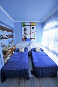2 camas en una habitación con paredes azules en Huerta Bonela, en Casarabonela