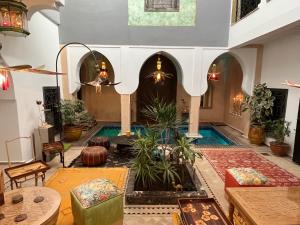 - un salon avec une piscine dans une maison dans l'établissement Riad Al Ibtikar, à Marrakech