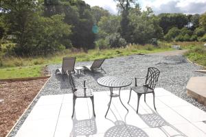 een groep stoelen en een tafel op een patio bij The Old Poolhouse in High Bentham