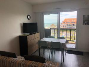 une salle à manger avec une table et une grande fenêtre dans l'établissement Prise de vue à 2 pas de la plage, à Villers-sur-Mer