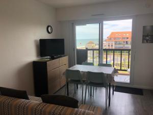 jadalnia ze stołem i dużym oknem w obiekcie Prise de vue à 2 pas de la plage w mieście Villers-sur-Mer