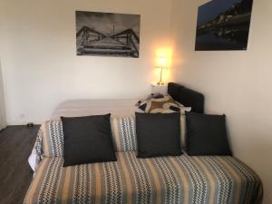 - une chambre avec un lit et des oreillers noirs dans l'établissement Prise de vue à 2 pas de la plage, à Villers-sur-Mer