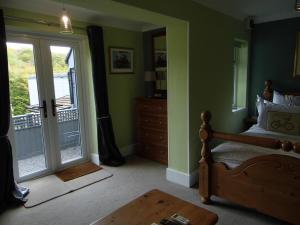 a bedroom with a bed and a sliding glass door at The Mill at Glynhir in Ammanford