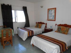 a hotel room with two beds and a window at Hotel y Bungalows Monteverde in Chachalacas