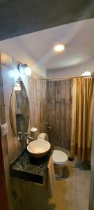 a bathroom with a sink and a toilet and a shower at HOTEL CAASAMA in Santa María