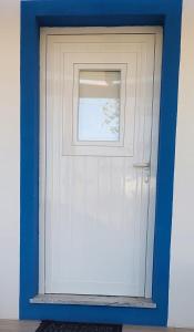 a blue and white garage door with a window at Casa Azul do Cerro in Campeiros