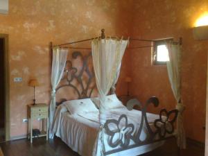 1 dormitorio con 1 cama con dosel de metal en Complejo Rural El Marañal en Caspueñas