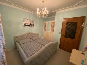 Schlafzimmer mit einem Bett und einem Kronleuchter in der Unterkunft Apartment Feistriz in Rosental 9181 in Feistritz im Rosental