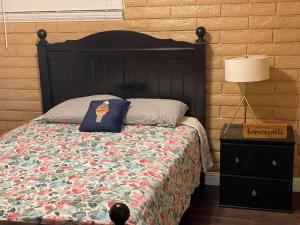 a bedroom with a bed with a black headboard and a lamp at Relaxing River Family Retreat in Bullhead City