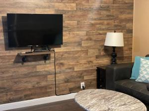 a living room with a television on a wooden wall at Relaxing River Family Retreat in Bullhead City