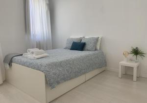 a white bedroom with a bed with towels on it at Casa do Gaspar in Aveiro