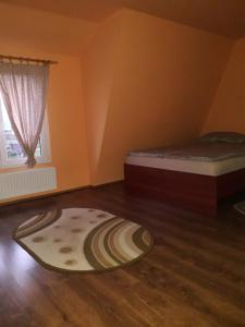 um quarto com duas camas e um tapete no chão em Timi Kulcsosház em Lăzarea