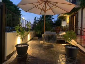 a patio with an umbrella and a chair and a table at Hotel Iride by Marino Tourist in San Vito lo Capo +176 photos