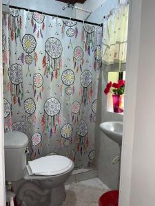 uma casa de banho com uma cortina de chuveiro e um WC. em Posada Nativa Trinsan Campestre em San Andrés