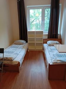 two beds in a room with a window at Hostel Sunrise Liwska in Warsaw