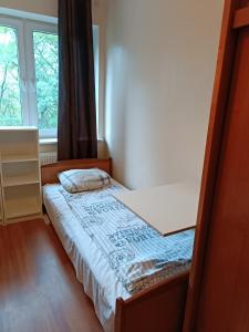 małe łóżko w pokoju z oknem w obiekcie Hostel Sunrise Liwska w Warszawie