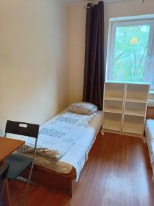 a small bedroom with a bed and a window at Hostel Sunrise Liwska in Warsaw