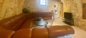 - un salon avec un canapé et des tables en cuir brun dans l'établissement SUNRISE VIEW VILLA, à Qala