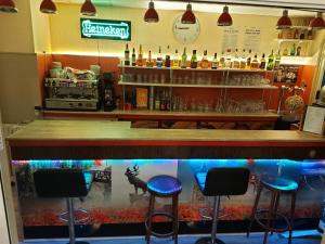 a bar with four stools in front of a fish tank at Hotel De La Paix in Albert