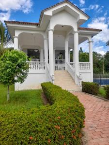 una casa bianca con portico e scale di Casa de verano Condominio el Imperio a Carmen de Apicalá