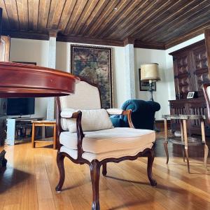 a living room with a chair and a piano at Casa de Santa Bárbara - Cinfães in Cinfães