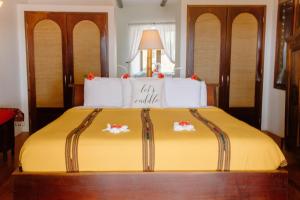 1 dormitorio con 1 cama con sábanas amarillas y almohadas blancas en La Perla del Caribe - Villa Amber en San Pedro