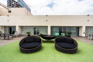 two bean bag chairs sitting on the grass in front of a building at Elite 47 Interlomas in Mexico City