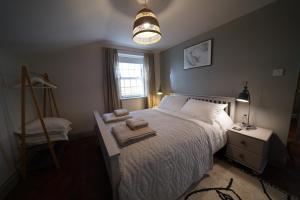 a bedroom with a bed with towels on it at Walmer, Deal stunning coach house apartment in Walmer