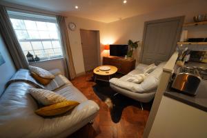 a living room with two couches and a table at Walmer, Deal stunning coach house apartment in Walmer