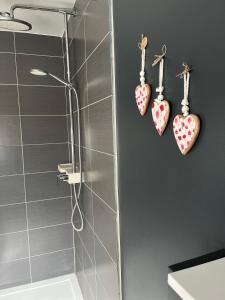une salle de bains avec des crochets en forme de cœur sur le mur. dans l'établissement Little gate, à Ypres