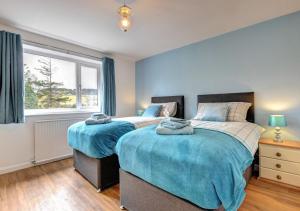 two beds in a bedroom with a window at Glan Donau in Llanuwchllyn