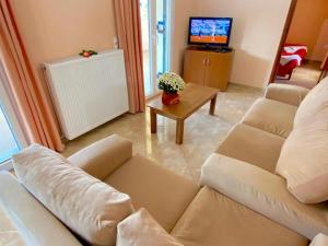 ein Wohnzimmer mit Sofa und Fernseher in der Unterkunft Anna Apartments in Acharavi