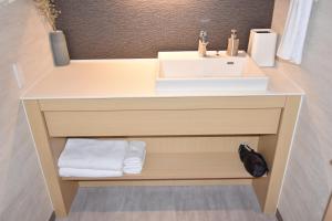 a bathroom with a sink and a counter with towels at K-style gosyonishi in Shimmachidōri
