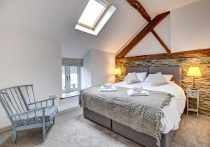 a bedroom with a large bed and a chair at Llety Tanllan in Darowen