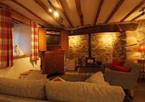a living room with a couch and a fireplace at Penclogwynau in Dolgellau