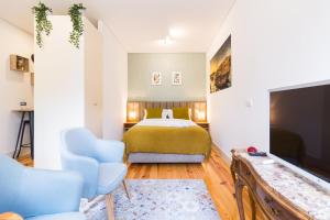a bedroom with a bed and a flat screen tv at Oporto Near Trindade Garden View in Porto