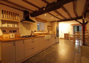 a large kitchen with white cabinets and a table at Penclogwynau in Dolgellau