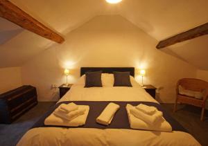 a bedroom with a large bed with two towels on it at Penclogwynau in Dolgellau