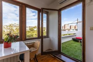 a room with windows and a table with a view at Spacious Loft with one bedroom and a big terrace in Belgrade