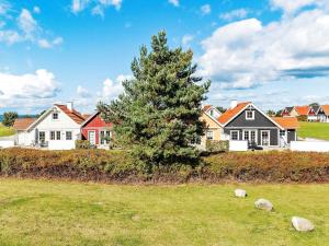 un grupo de casas y un árbol en un campo en 6 person holiday home in Brenderup Fyn, en Bro