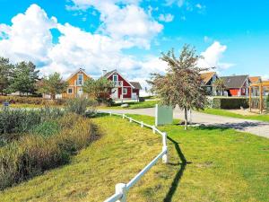 a white fence in a yard with houses at 6 person holiday home in Brenderup Fyn in Bro