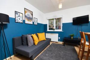 Una sala de estar con un sofá y una pared azul. en Lovely Apt in City Centre Leeds, en Leeds
